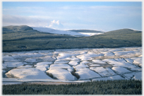 Lightly snow covered hillside with heavy undulations.