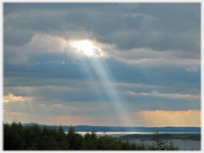 Shaft of sun coming from sky onto sea.