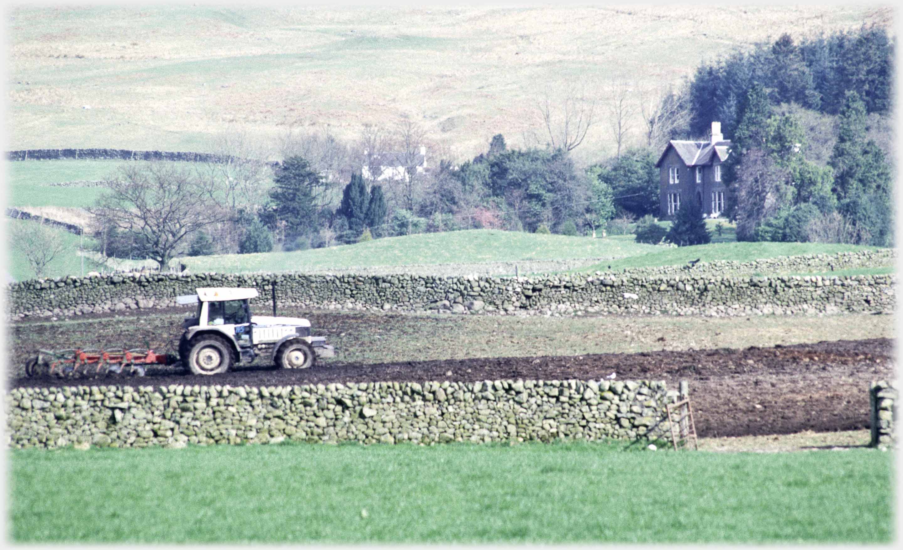 Closer shot of tractor and house.