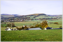 Wooded hills beyond wooded town.