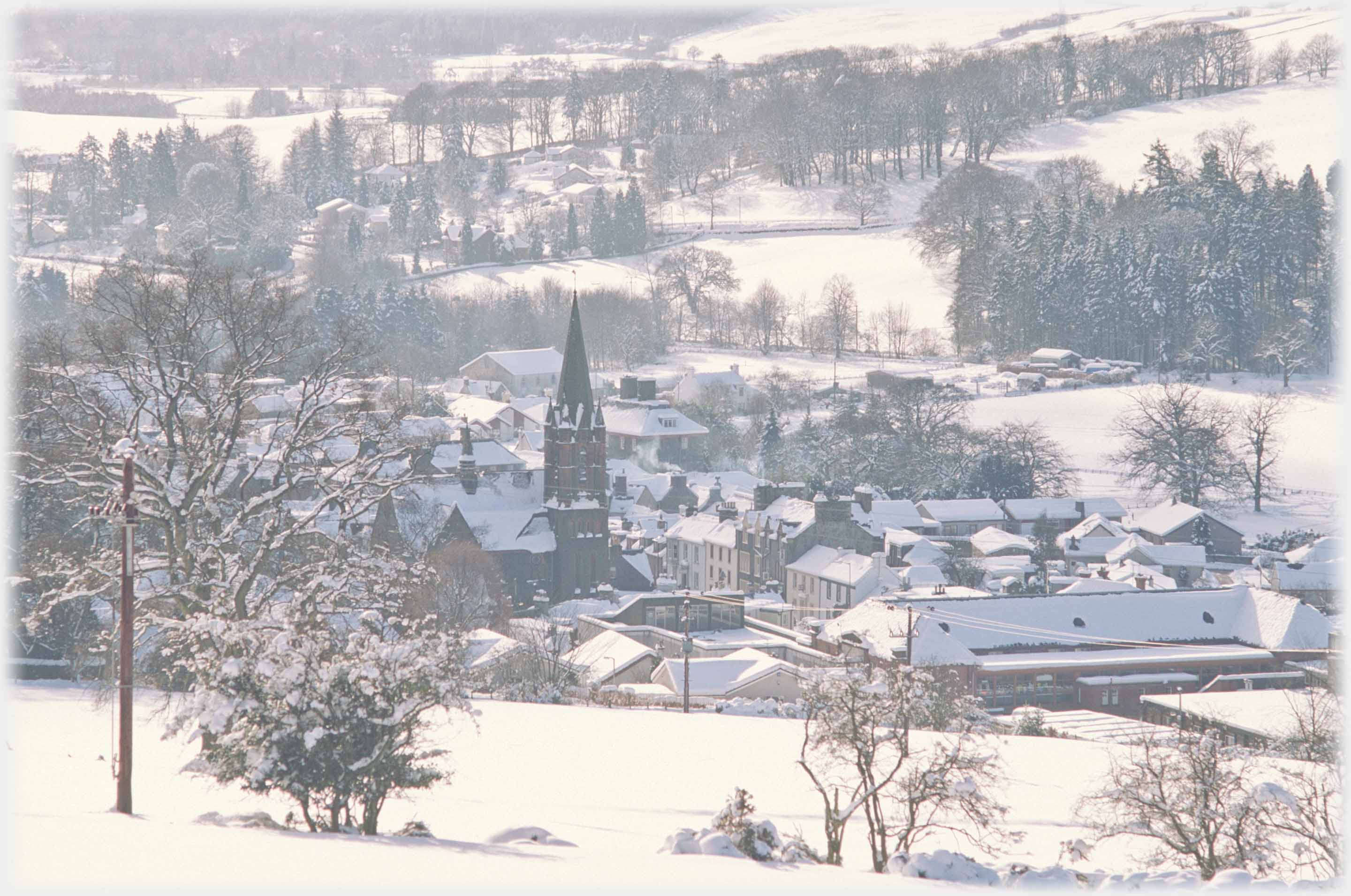 Looking down at sasme church and buildings with all covered in snow.