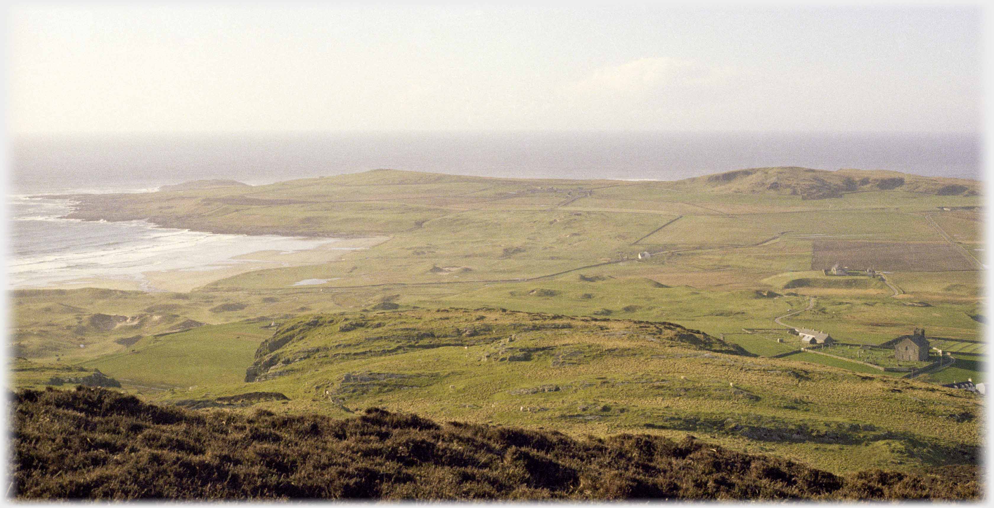 Bay area with sea beyond and church to right.