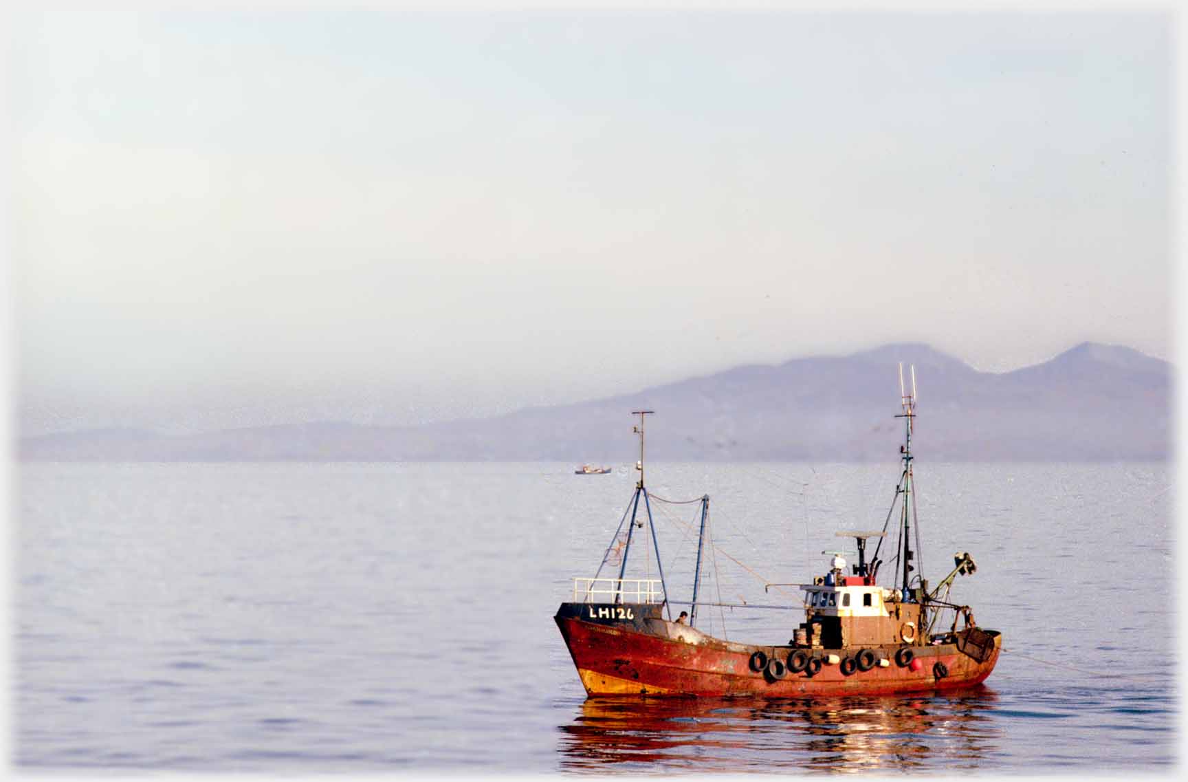 Rust cloured boat reflecting in sunlight.