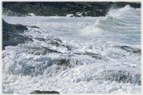 Waves swirling over a rocky shore.