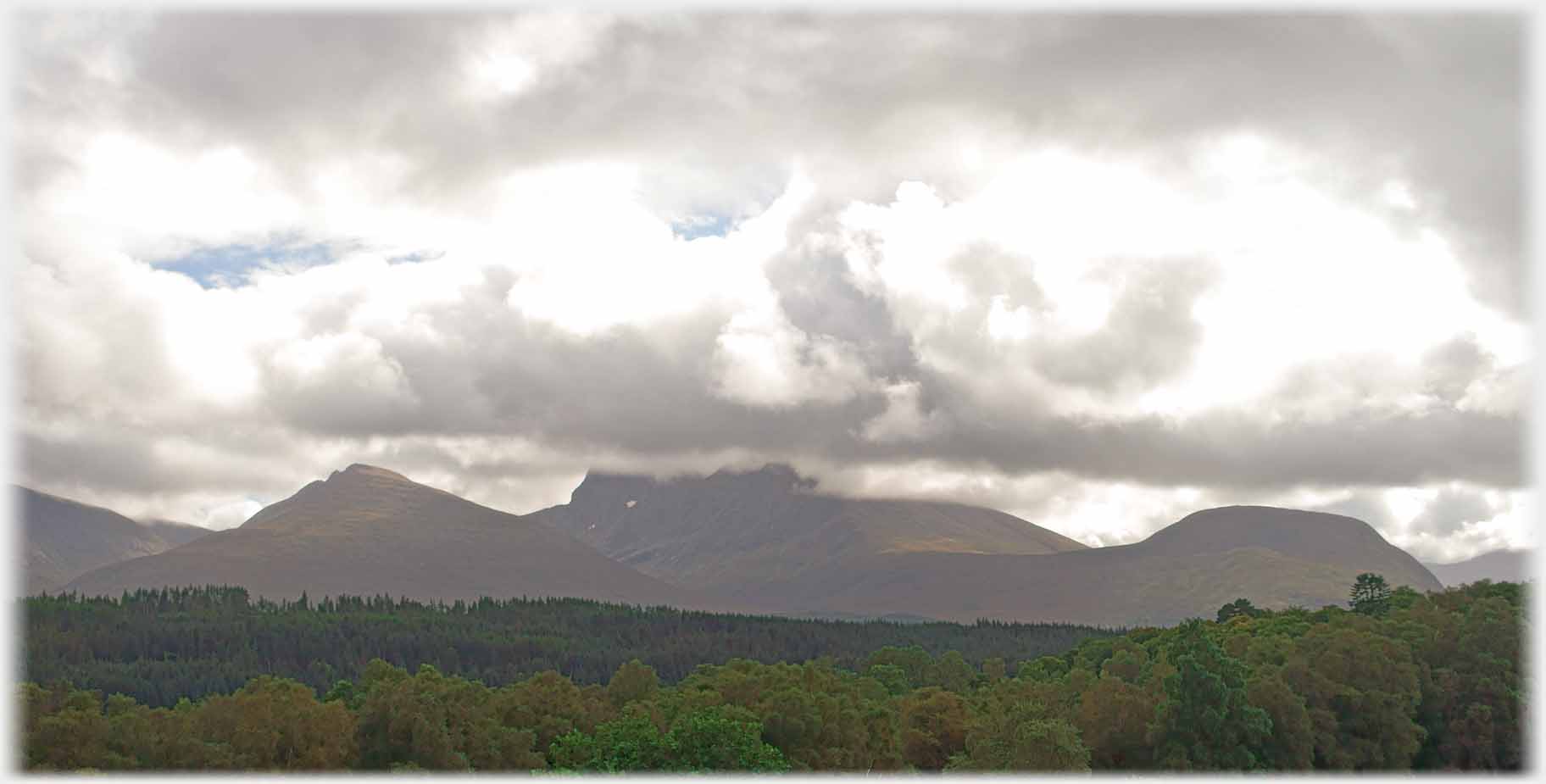 Mountain range with clouds capping the tops.