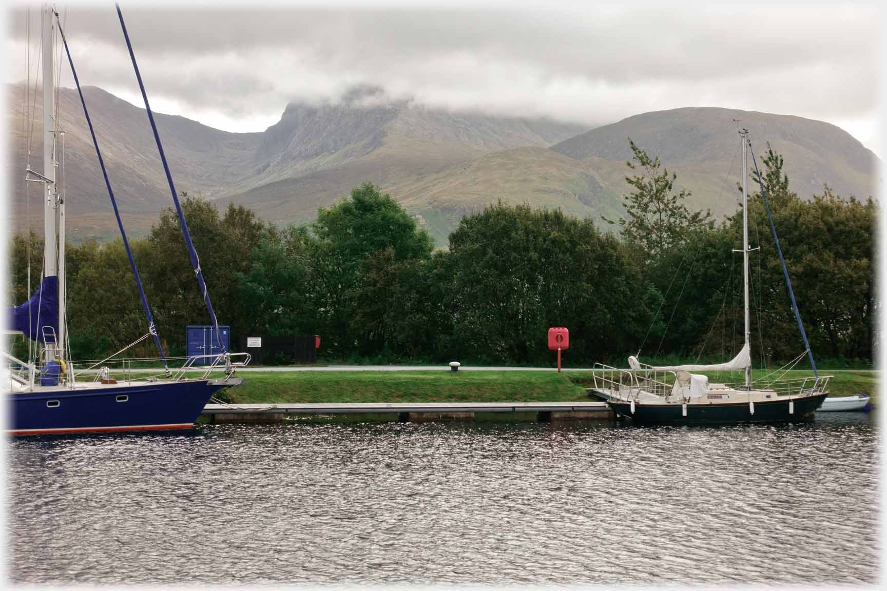 Looking across canal to the lower mass of cloud topped mountain.