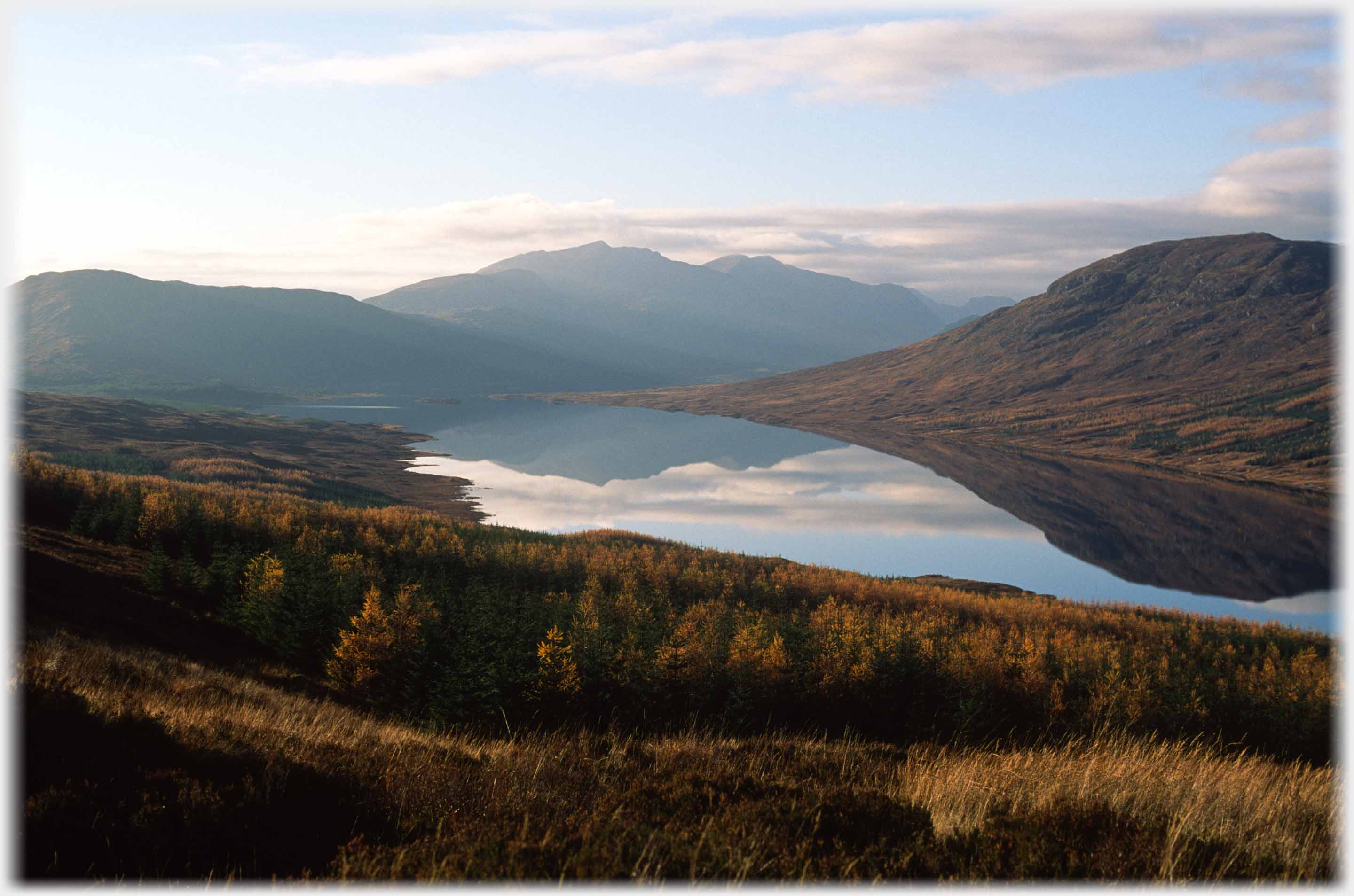 Still waters of loch with hills refelcted.