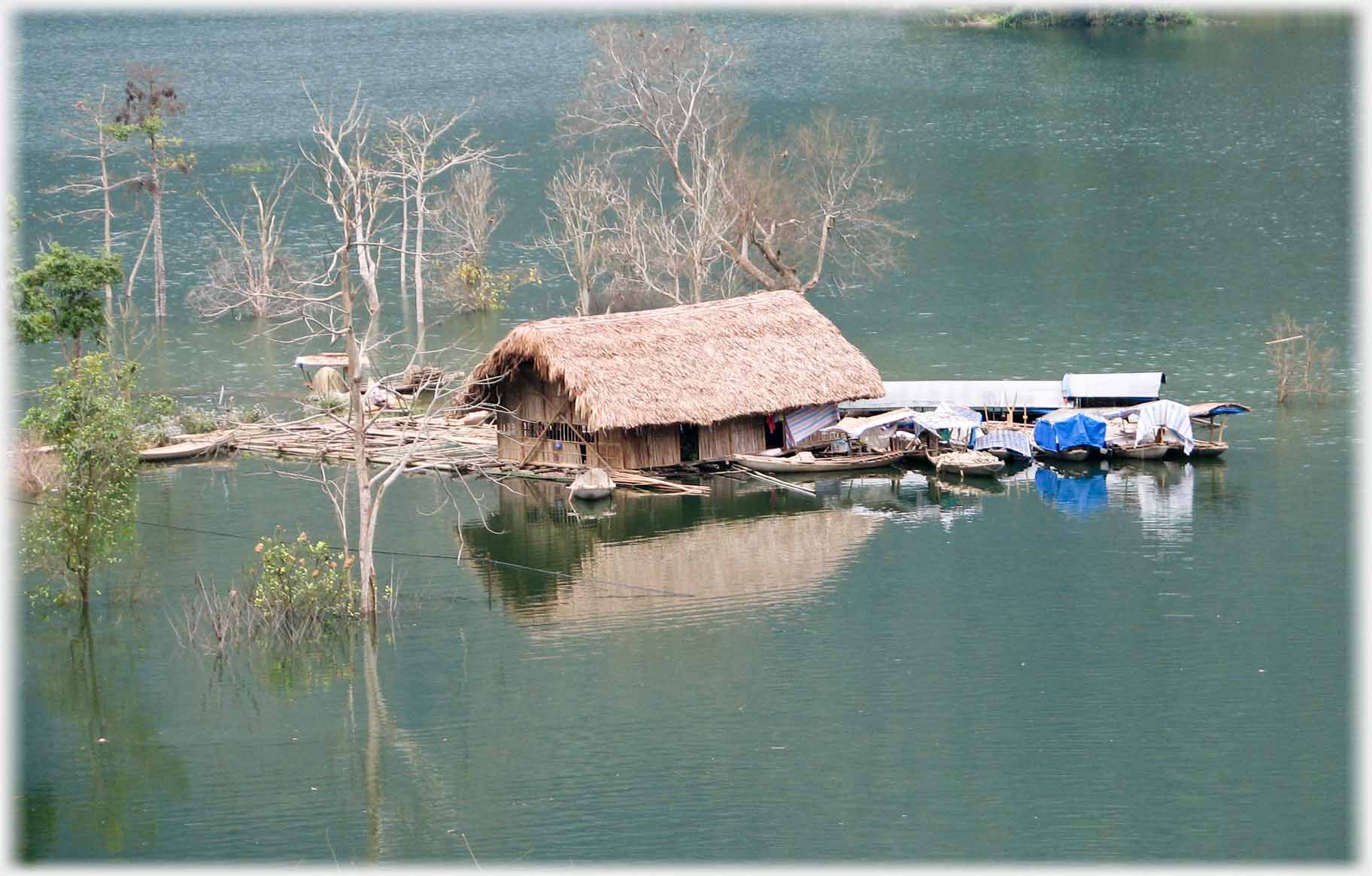 Apparent lake under hills with houseboat.