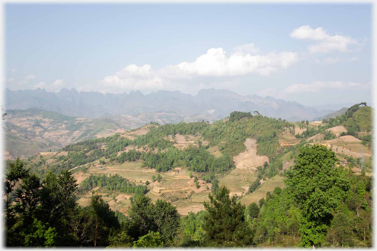 Clear hills with light woodland and distant mountains.