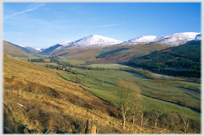 Valley with line of snow capped hills.