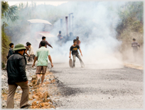 Men working in smoke and new laid road.