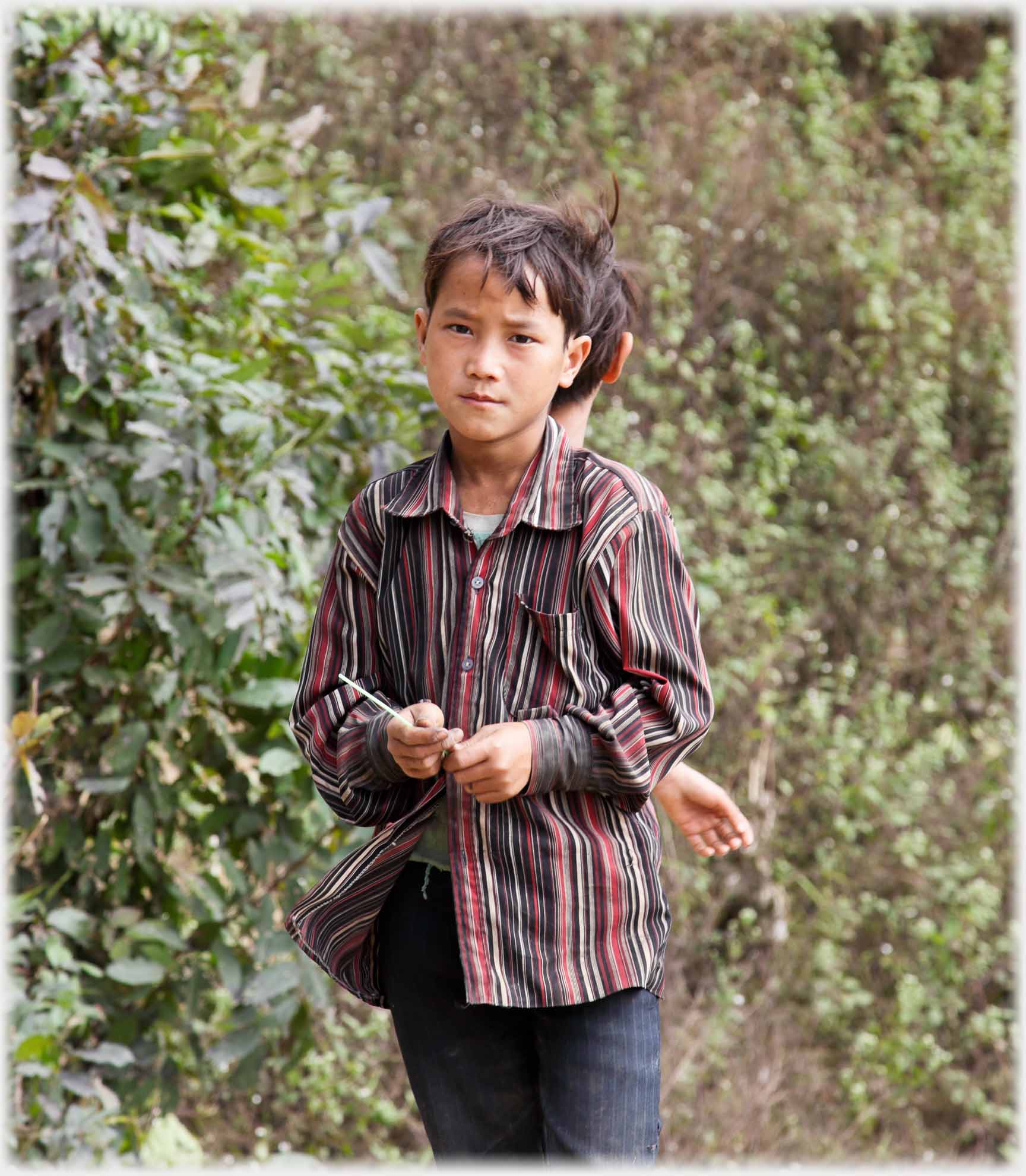 Boy looking at camera, with apparently third hand.