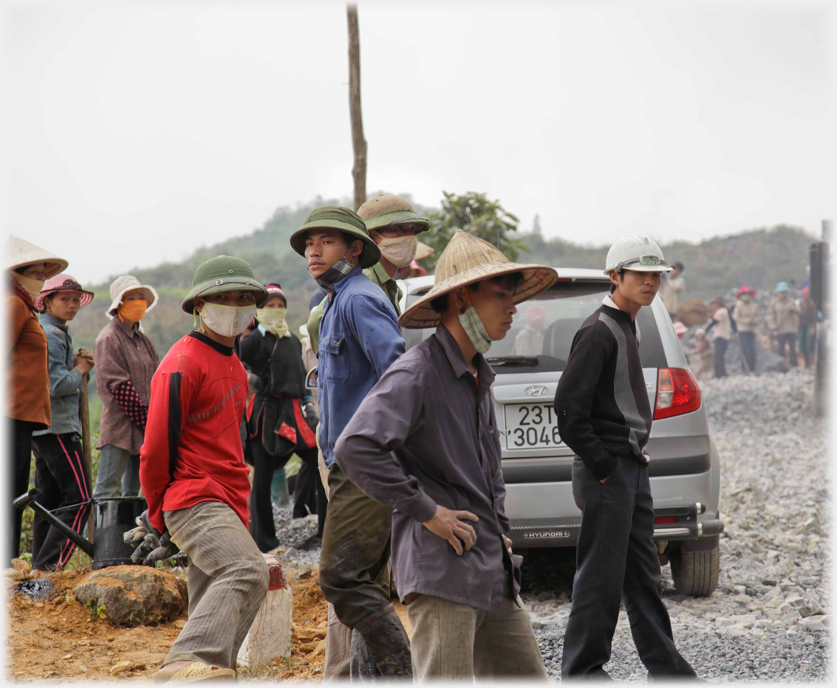 Group of workers standing by roadside.