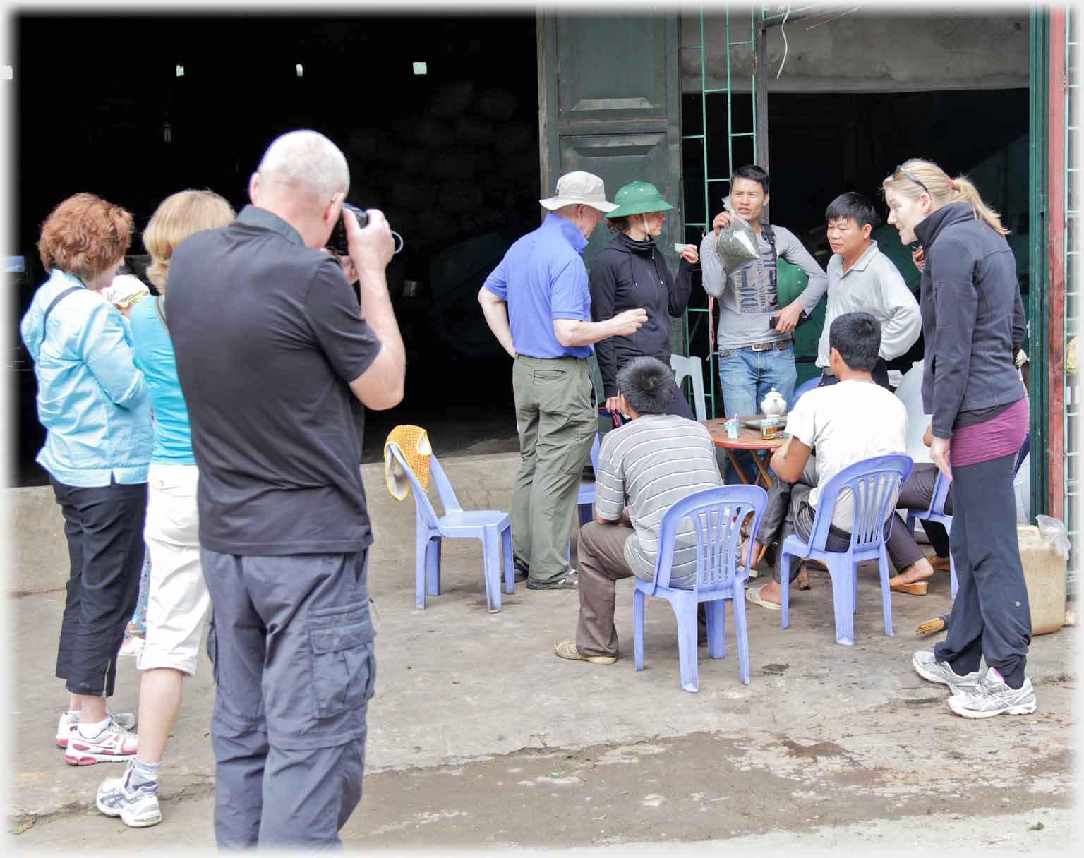 Group people looking at bag being held up, others watching the group.