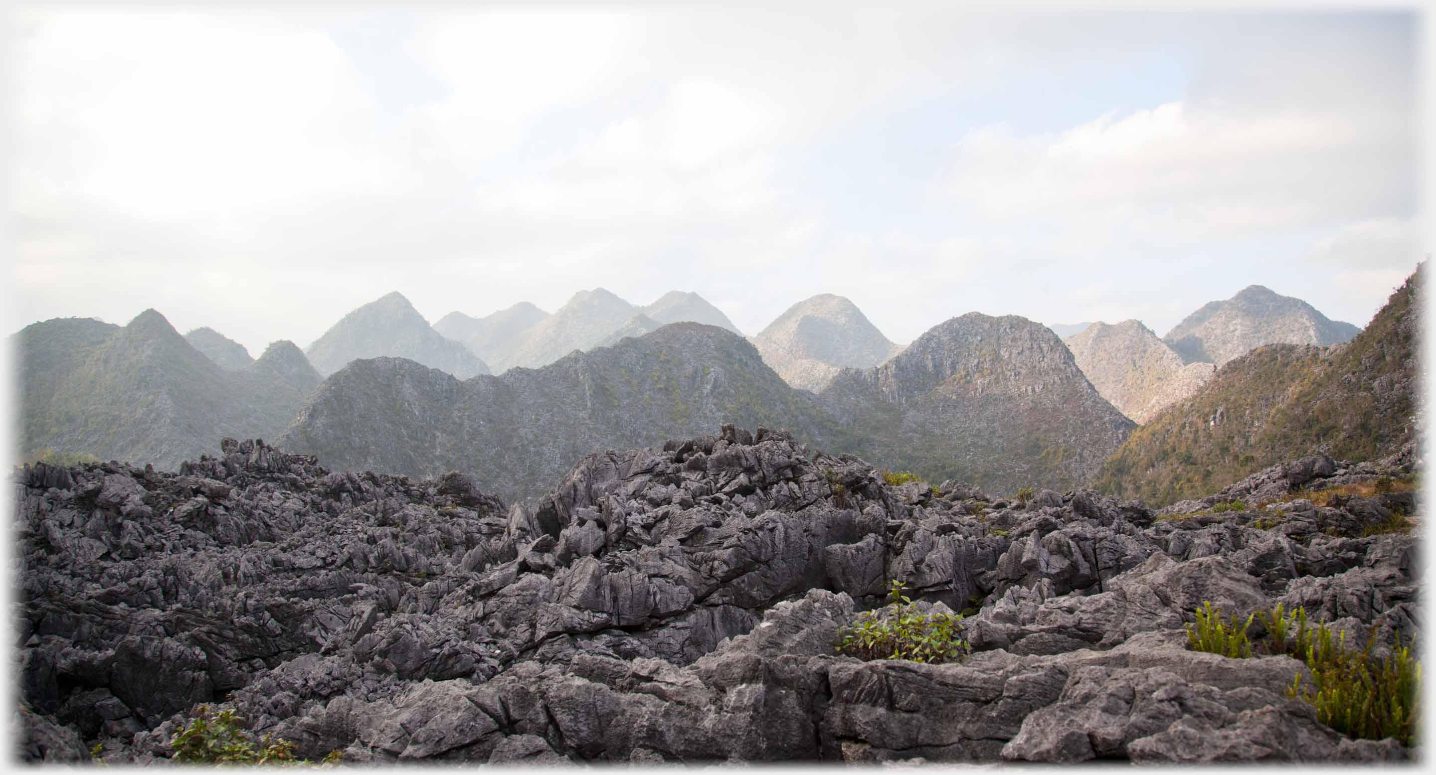 Foreground of rough rocks, behind karsts into the distance.