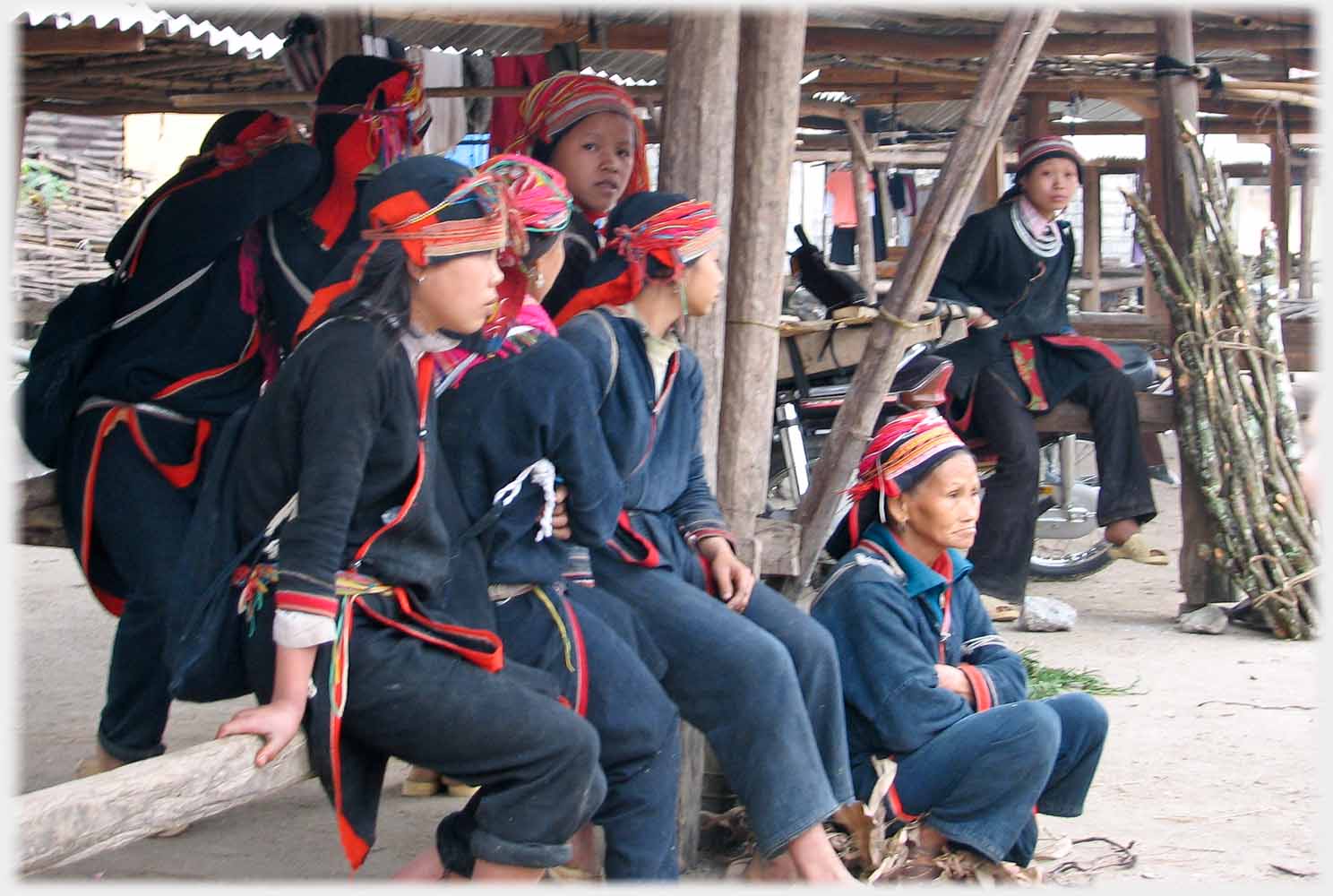Women sitting on beam.