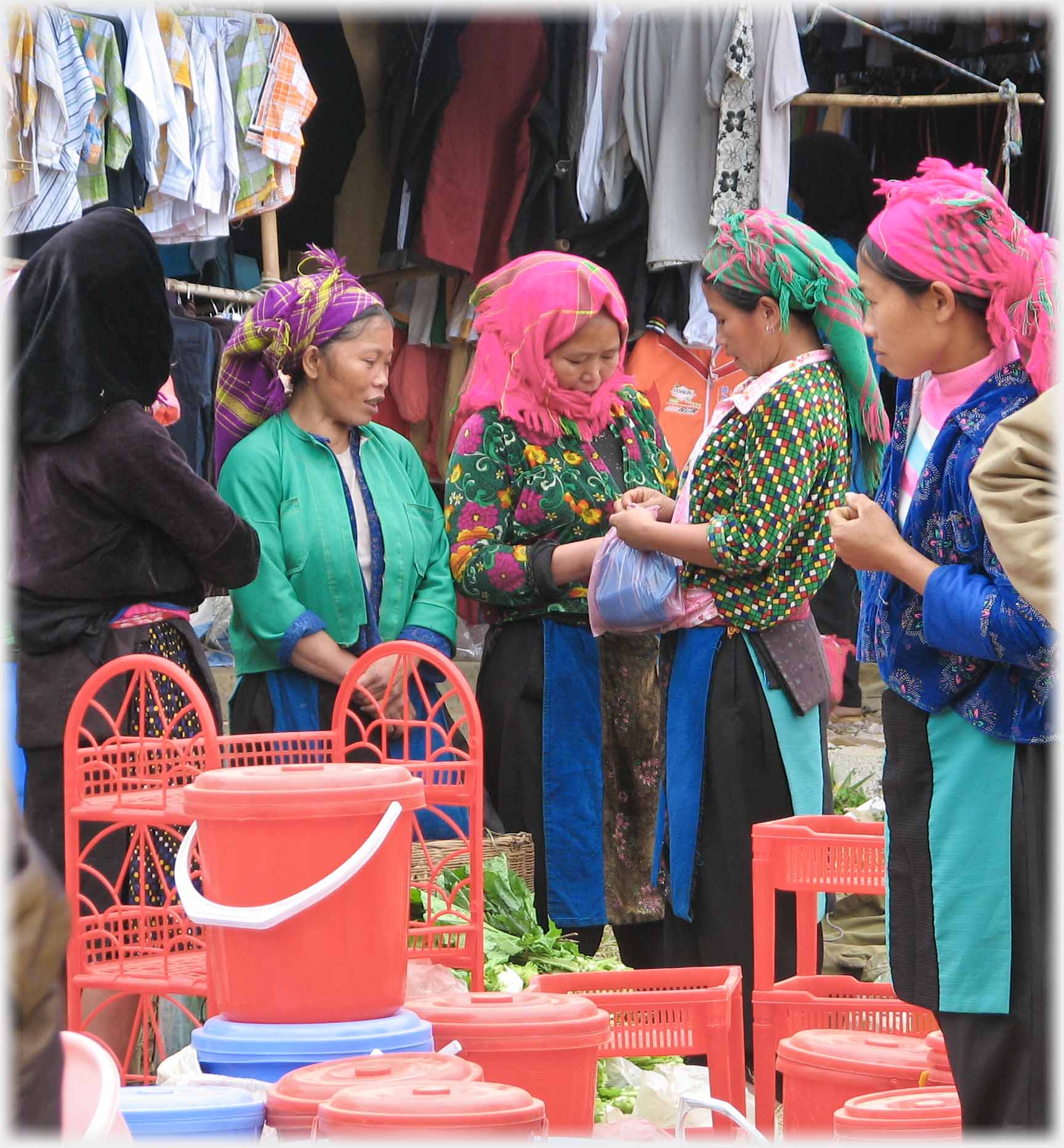 Four women by red household goods.