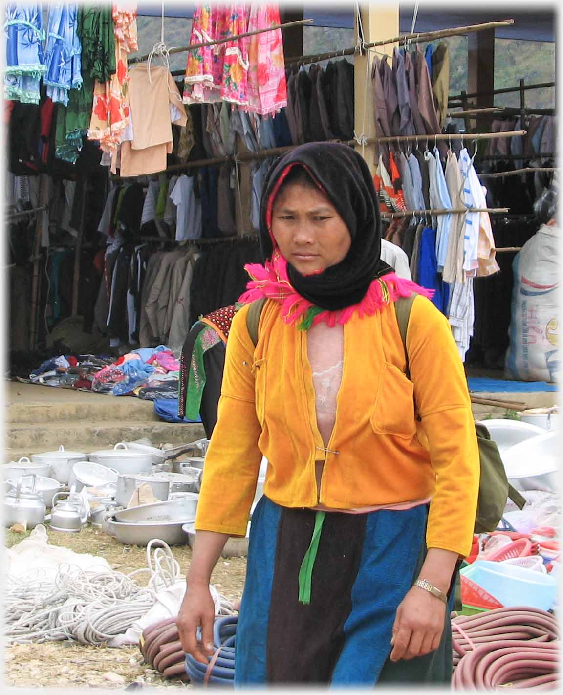 Woman in orange top and black headscarf.