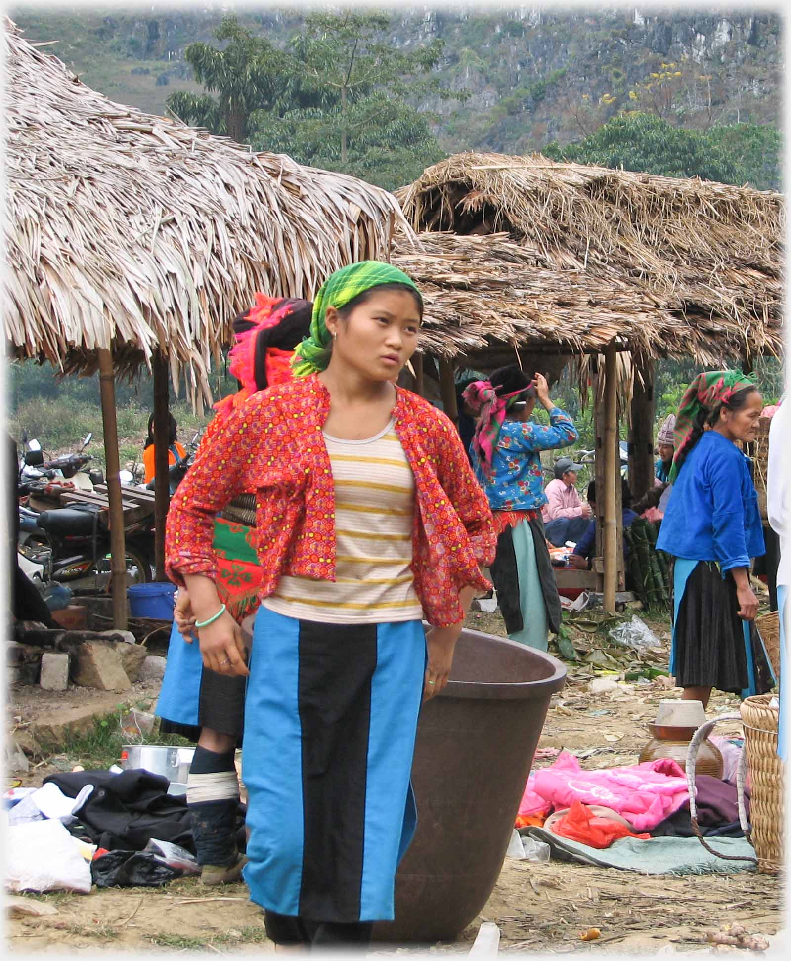 Another woman in orange top in front of that container.
