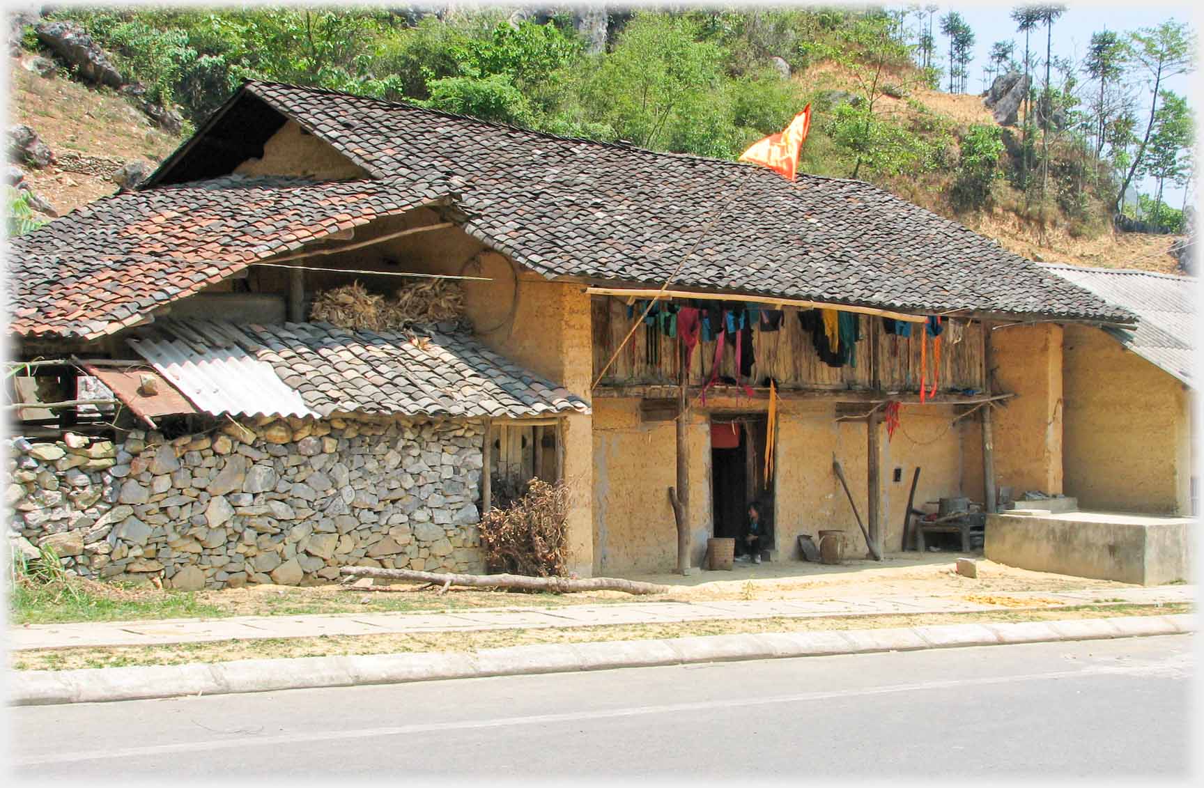 Pantiled two story house beside road.