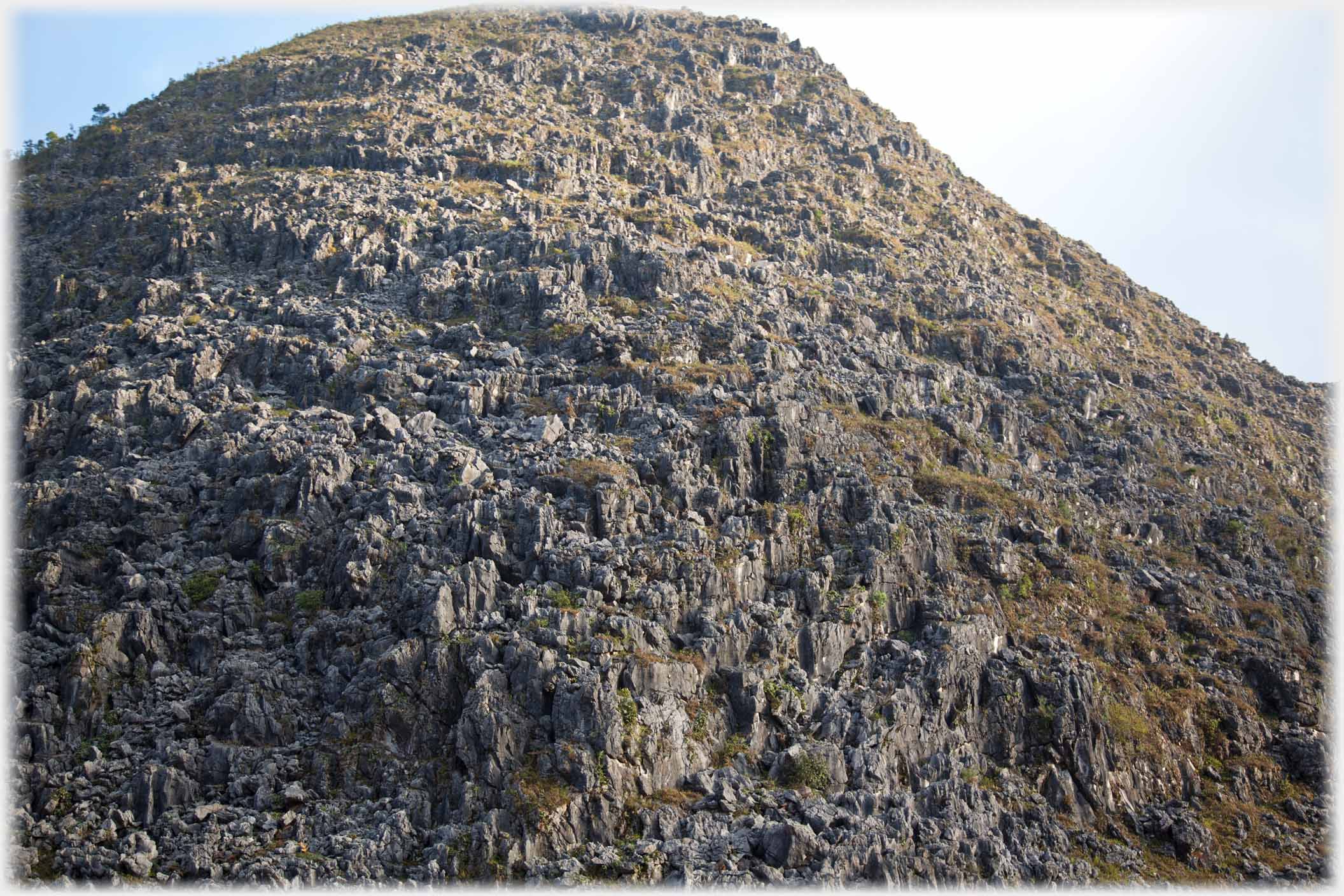 Steep hillside of formed of sharp rocks.