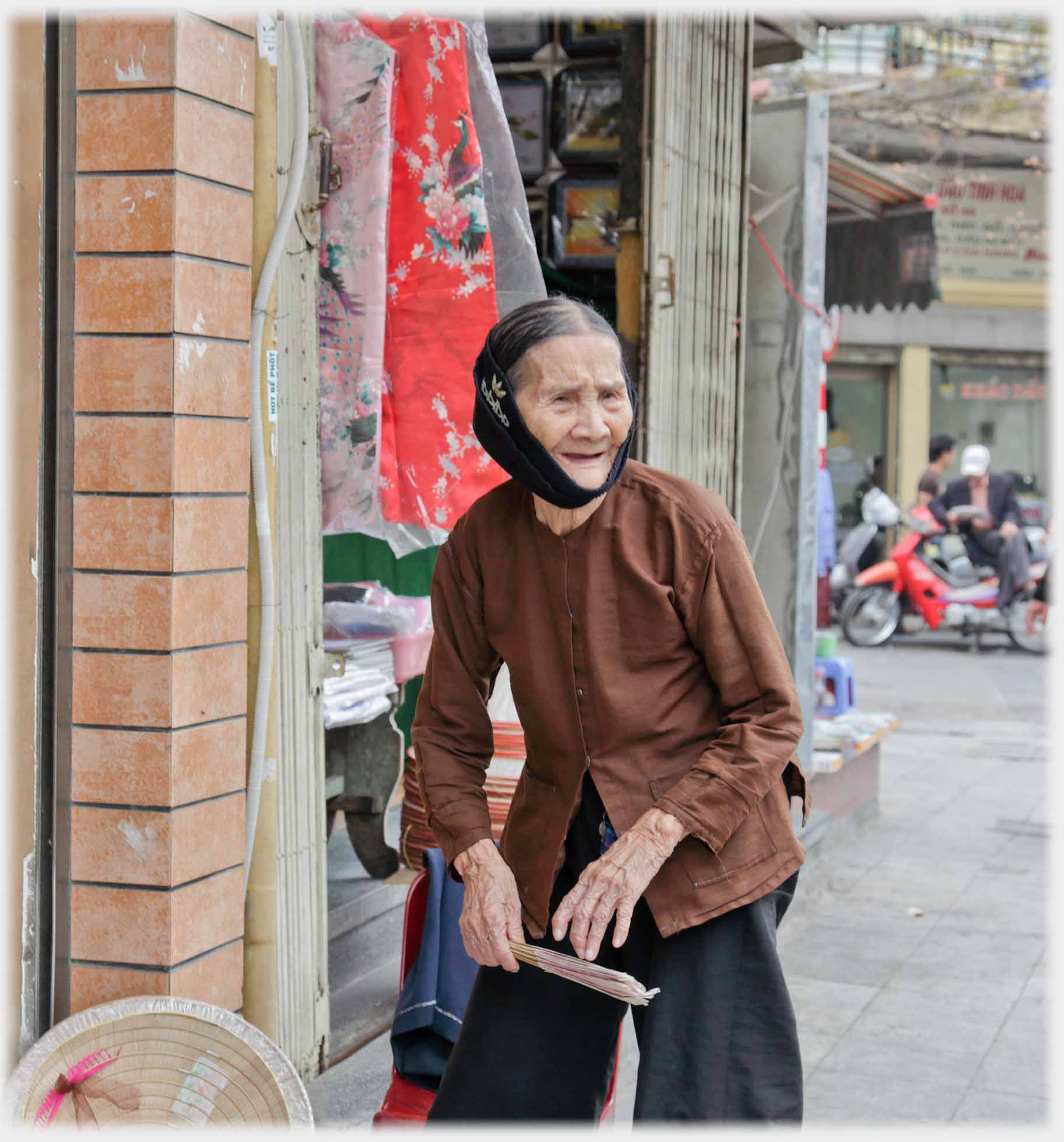 Older woman walking, her large hands noticeably knurled.