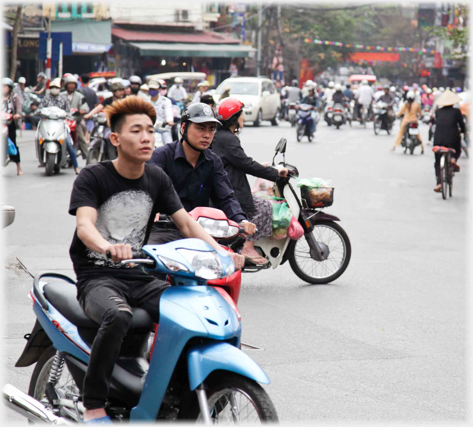 Motorcyclists, nearest one helmetless with reddened hair.
