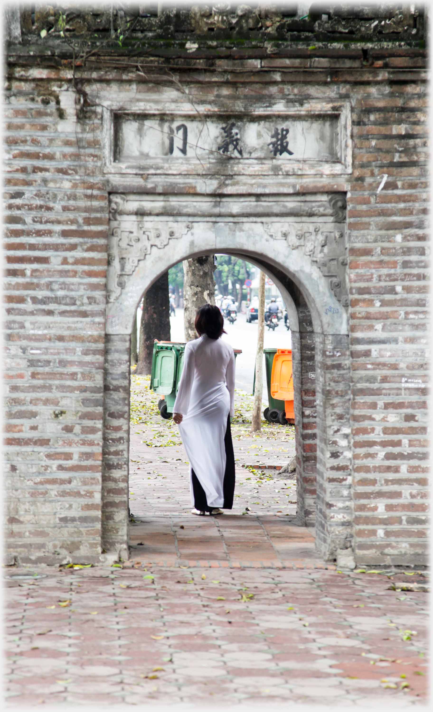 Woman in long white dress framed in an archway.