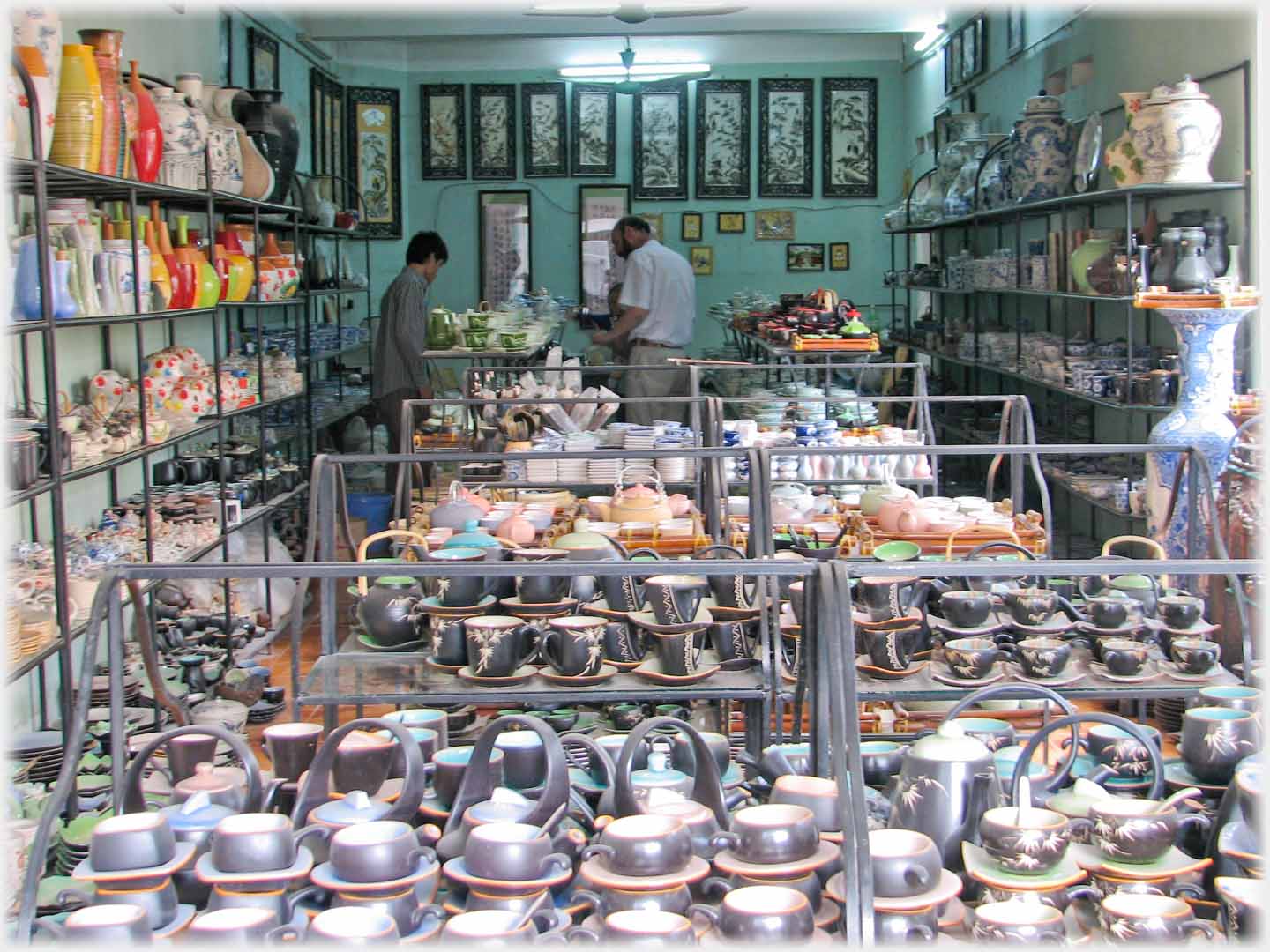 View into a ceramic shop, two men browsing at the rear of the display.