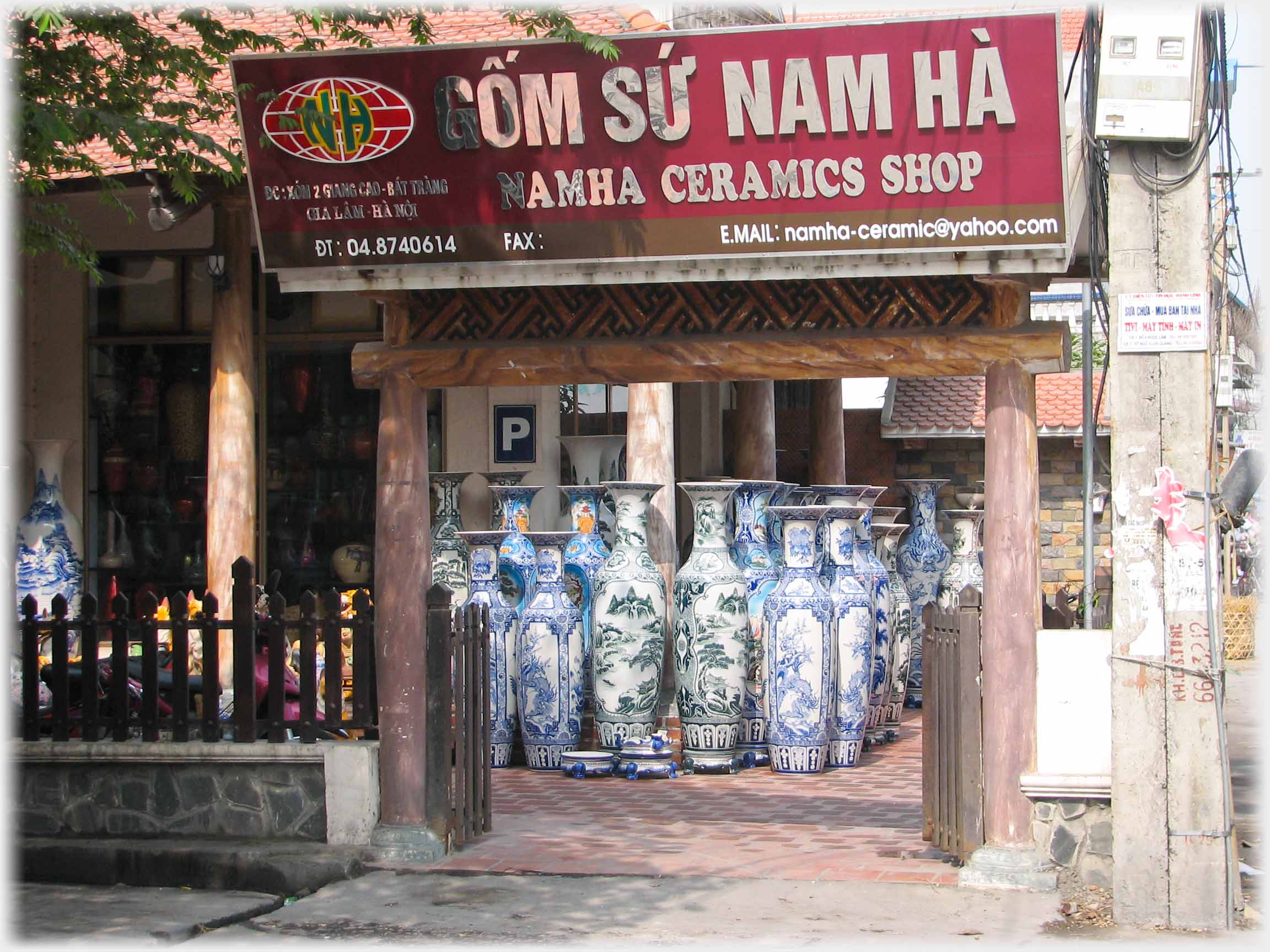 Entrance to Nam Ha shop with many vases standing by door.