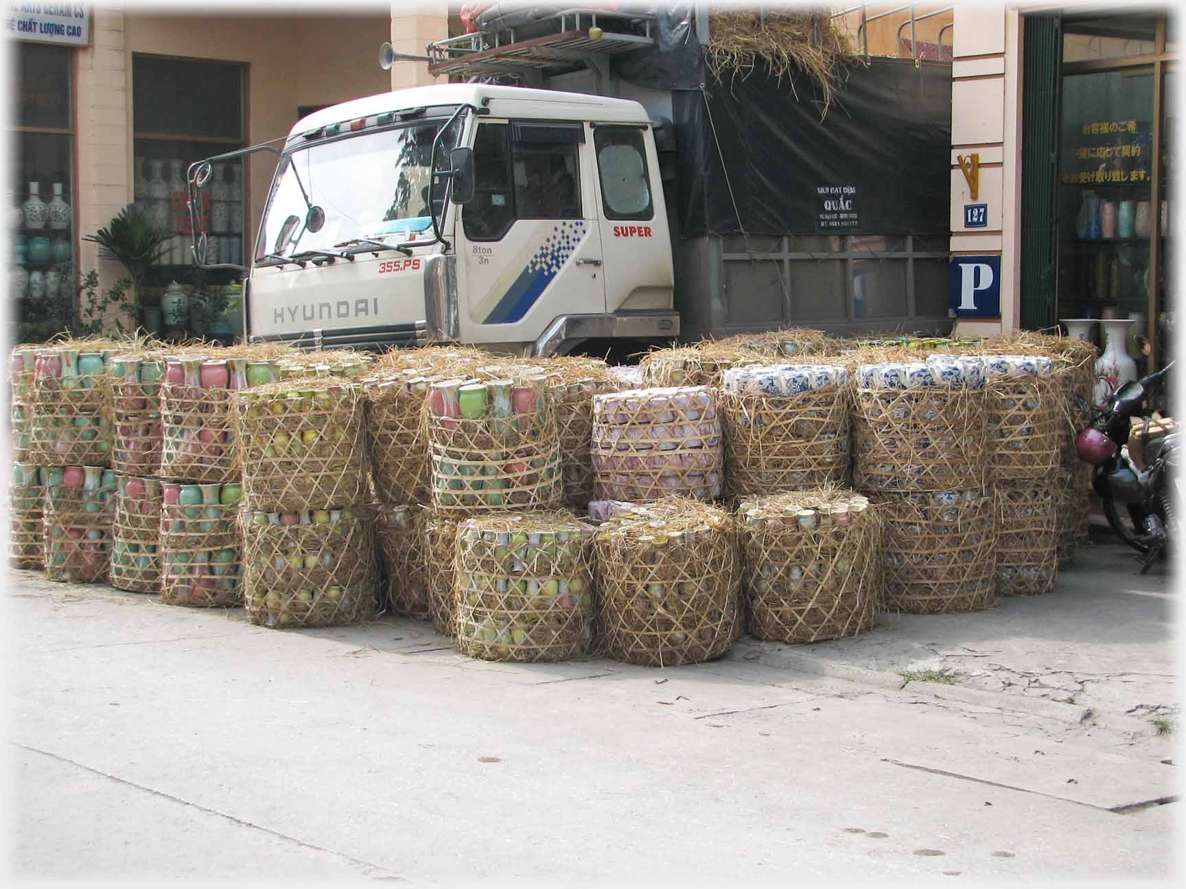 Dozens of wicker baskets waiting by a lorry to be transported.