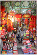 Veritable cave of lanterns with man sitting.