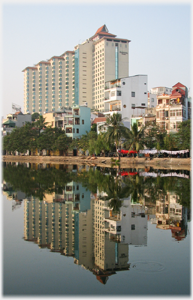 Large hotel reflected in water.