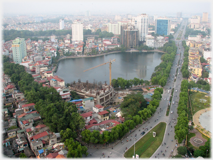 Lake with major road to right and tower blocks beyond.