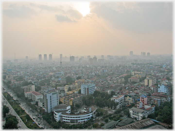 View across lower rise buildings towards tower blocks in slight merk.