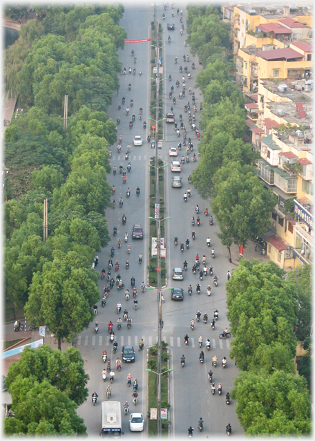 Six lane carriage way speckled with motorbikes.