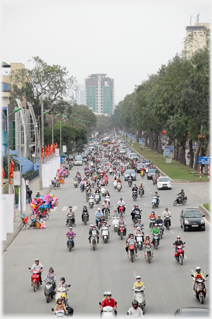 Section of 10 lane straight street with steady traffic.