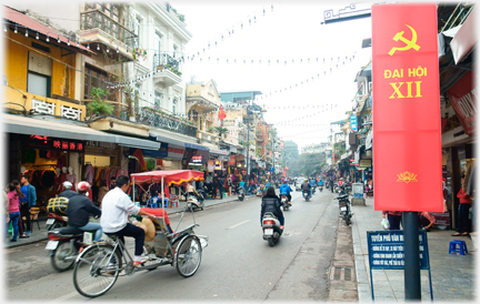 Main shopping street with littel traffic and rickshaw near-by.