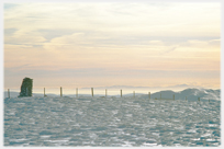 View from hilltop in snow over clouds to far hill.