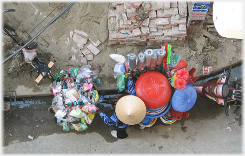 Looking down onto top of piles of circular kitchen items next to Vietnamese hat.