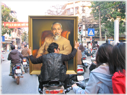 Pillion holding a large portrait of Chairman Ho.