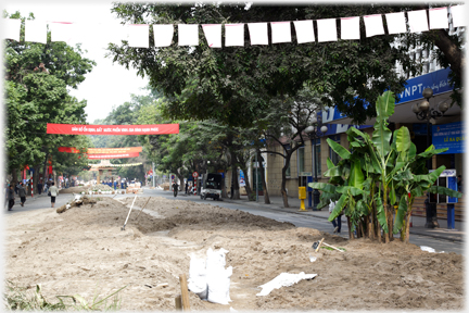 Wide street with whole central area covered in soil.