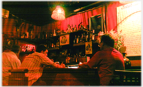 Men at bar in dim red light.