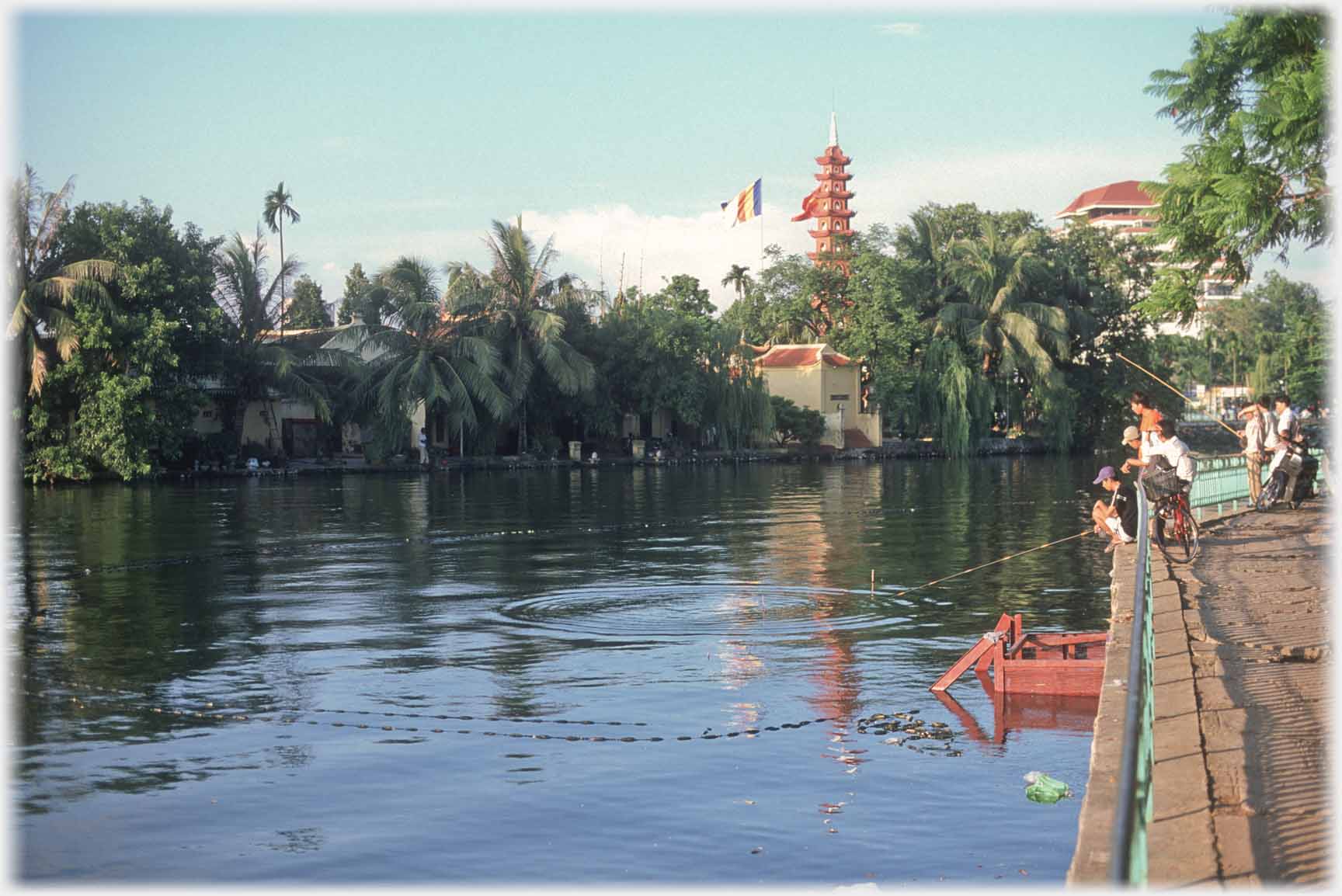 By backwater of lake, thick vegetaion and pagoda above.