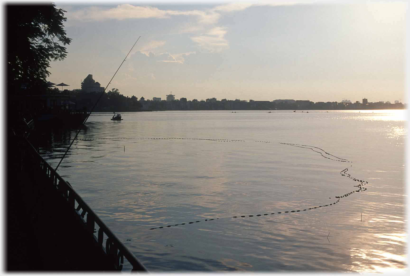 Dark shadows to left with rod point upwards, floats on the lake.