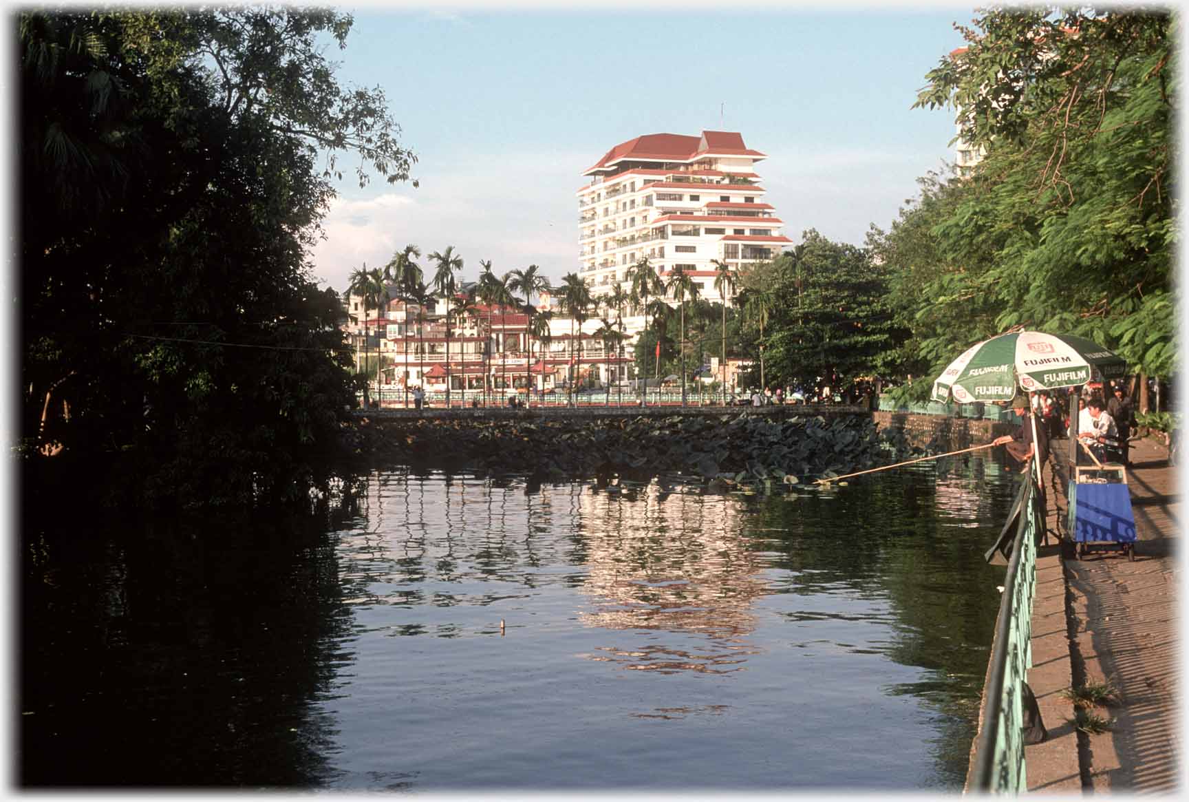 Looking along lake side towards houses with large hotel above them.