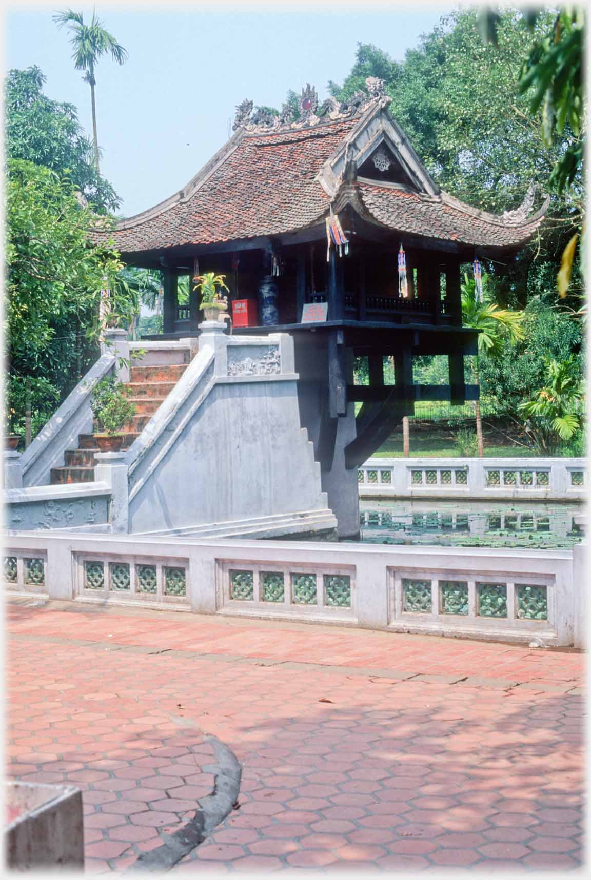 Paved area with no flowrs in front of balustrade, pagoda beyond.