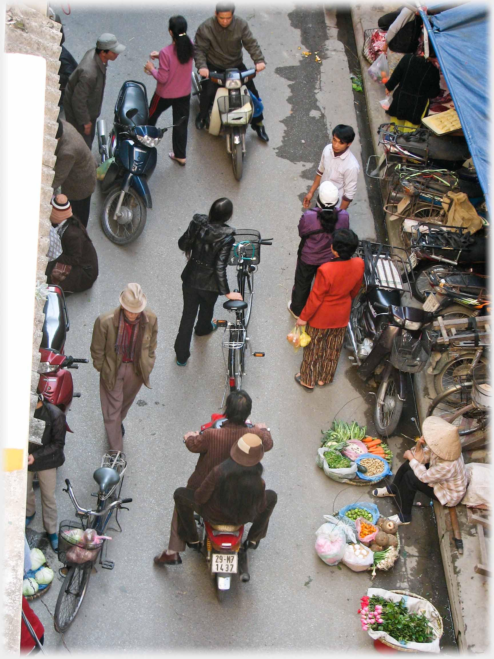 Looking down on busy lame with bikes and sellers.