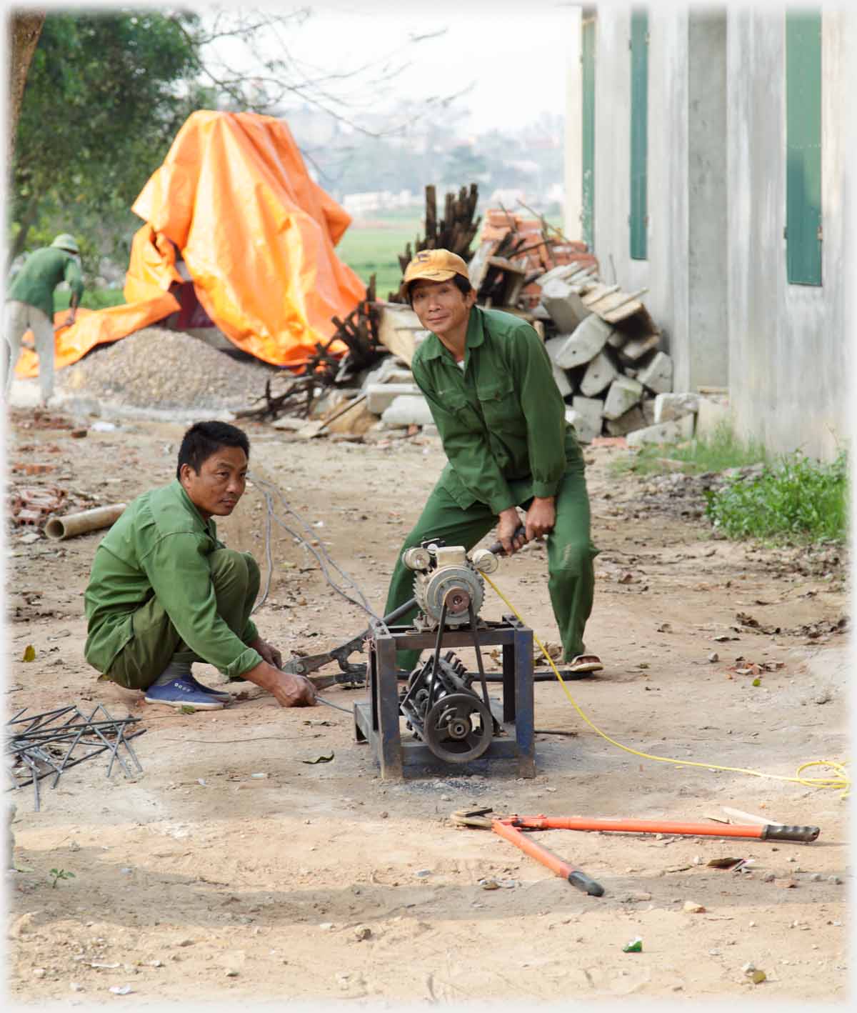 Two men bending a metal rod.