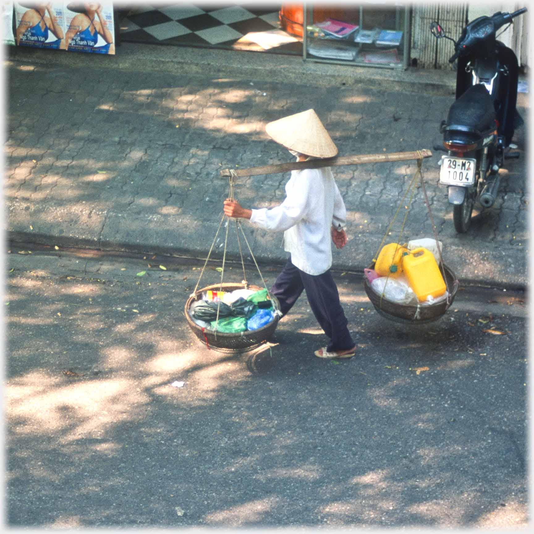 Woman with one pannier filled with large plastic cans.